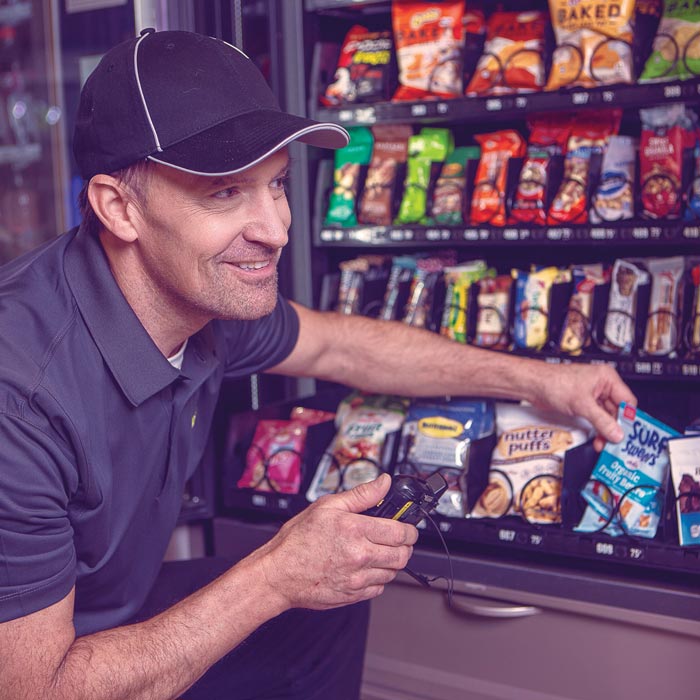 man restocking vending machine
